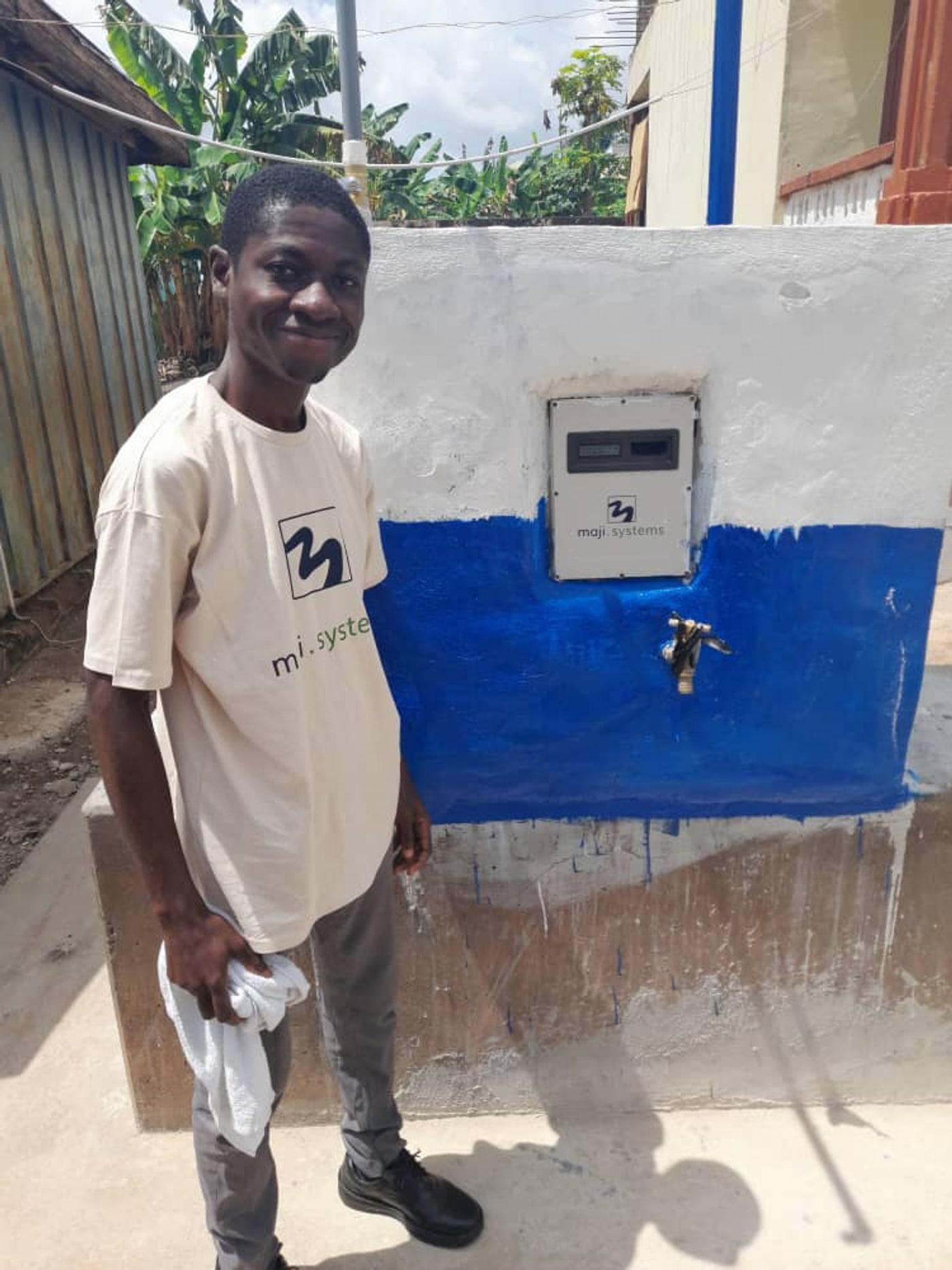 A Maji Systems team member beside a freshly installed Community Dispenser