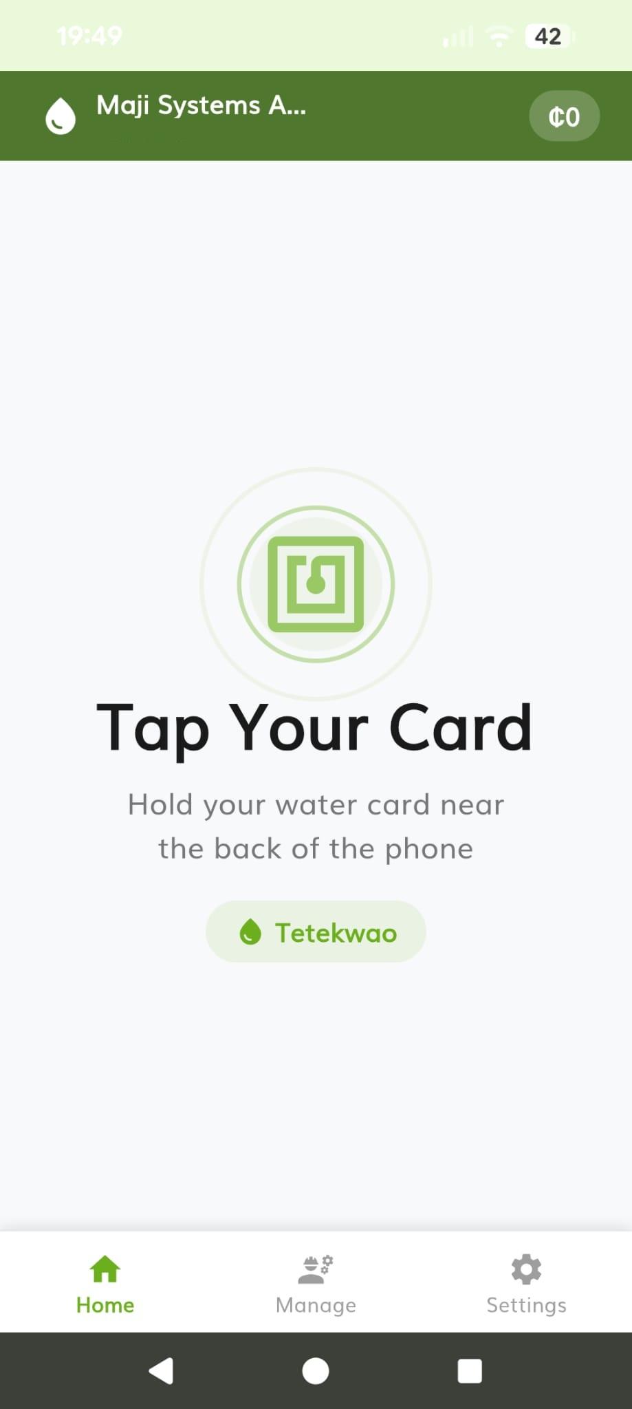 The Maji Systems app home screen, showing a large NFC symbol under the heading “Tap Your Card” and the current community, Tetekwao, below it